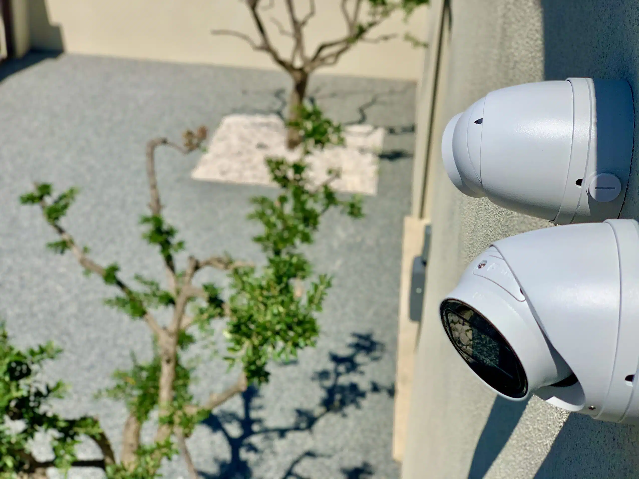 Deux caméras installées sous des gouttières surveillant une maison, garantissant une sécurité renforcée et une surveillance constante des alentours.