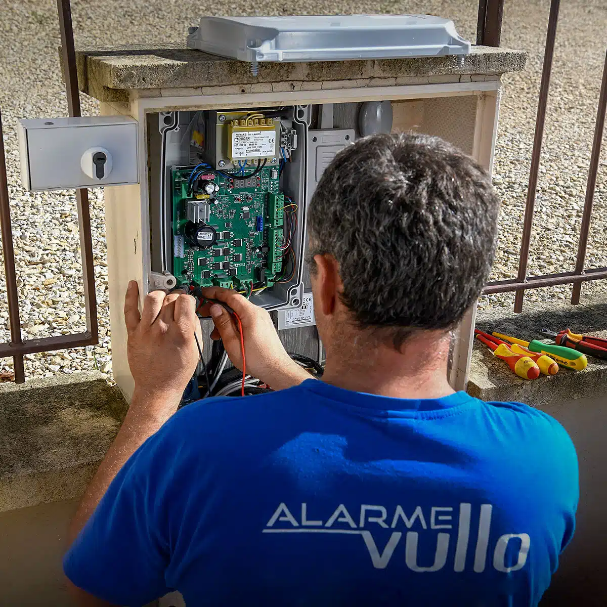 Installateur de dépannage intervenant sur un circuit électronique pour réparer et maintenir les systèmes de sécurité en parfait état de fonctionnement.