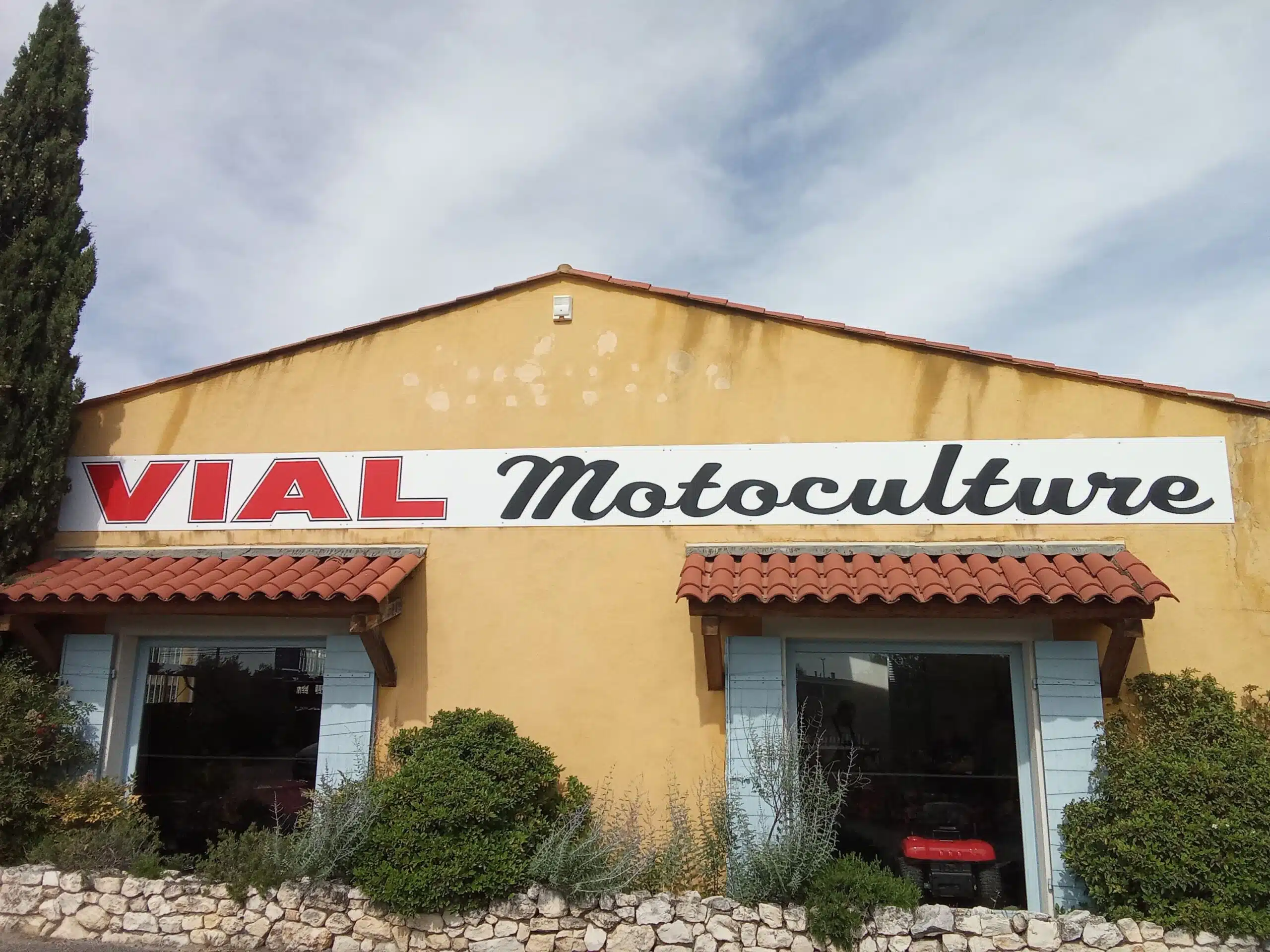 Logo de Vial Motoculture visible sur la devanture du magasin, symbolisant la fiabilité et l'engagement dans la vente et la maintenance d'équipements pour l'entretien de jardins et d'espaces extérieurs.