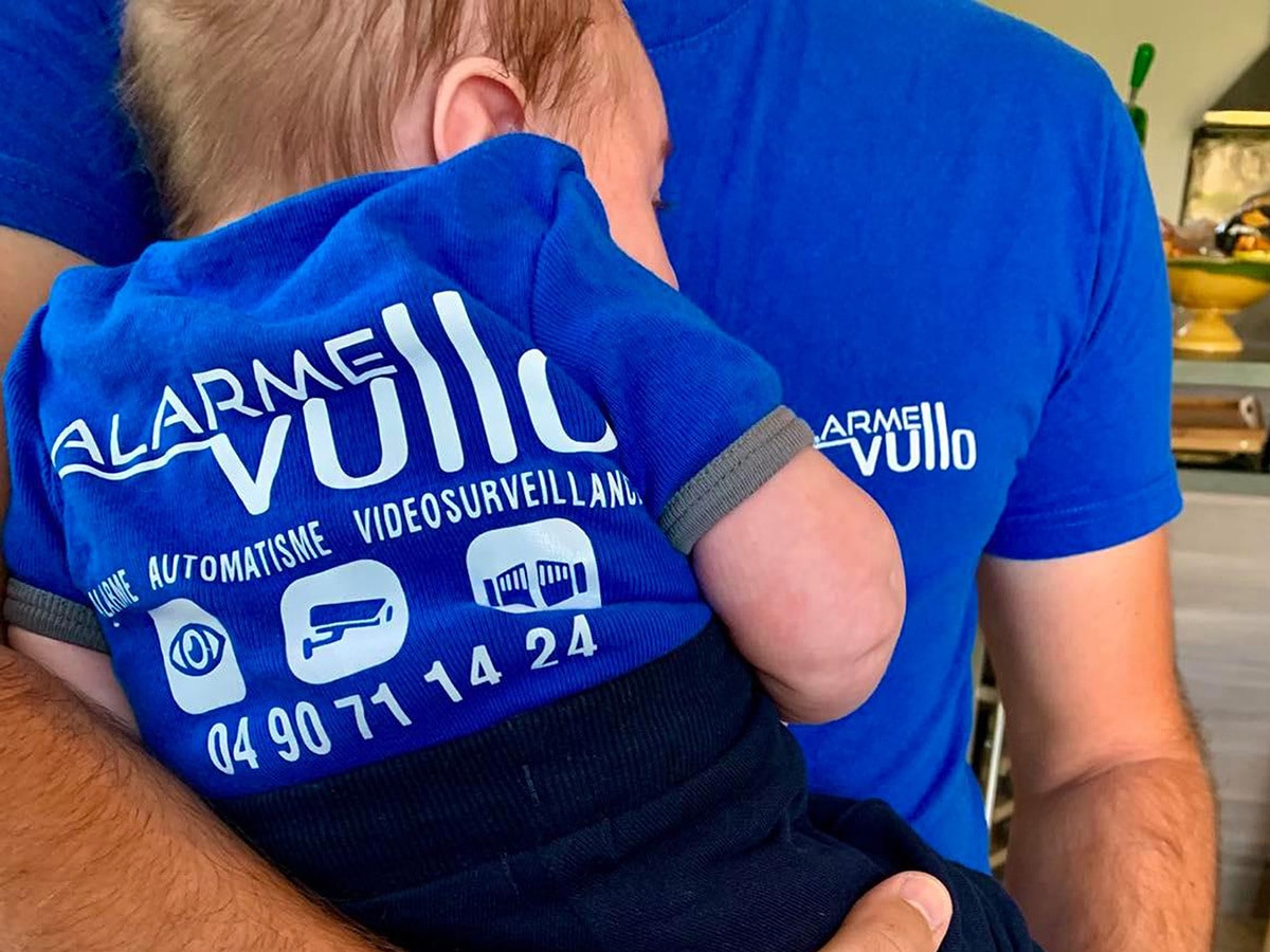 Bébé habillé d’un body avec le logo alarme Vullo.