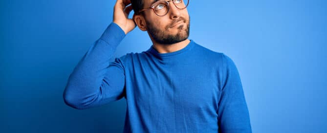 Homme réfléchissant à une solution d’alarme sans abonnement, sur un fond bleu évoquant la tranquillité et la confiance en une sécurité autonome.