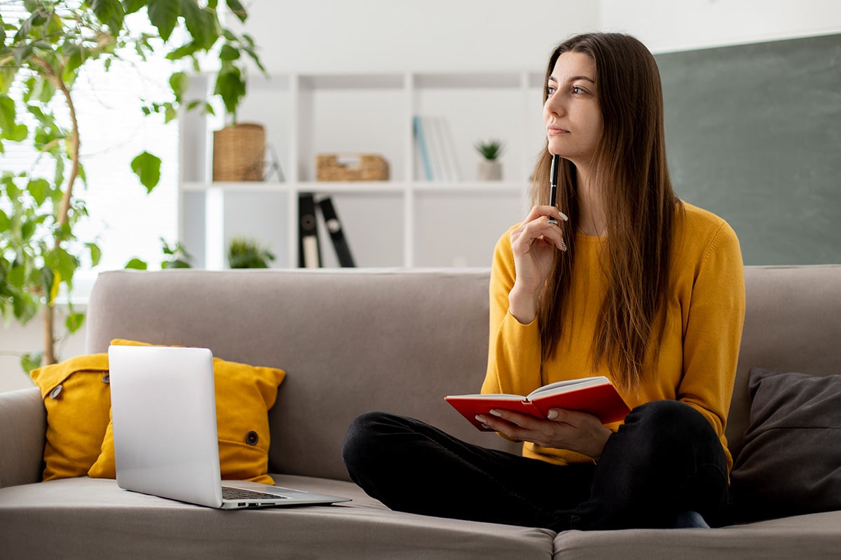 Femme pensive assise sur un canapé
