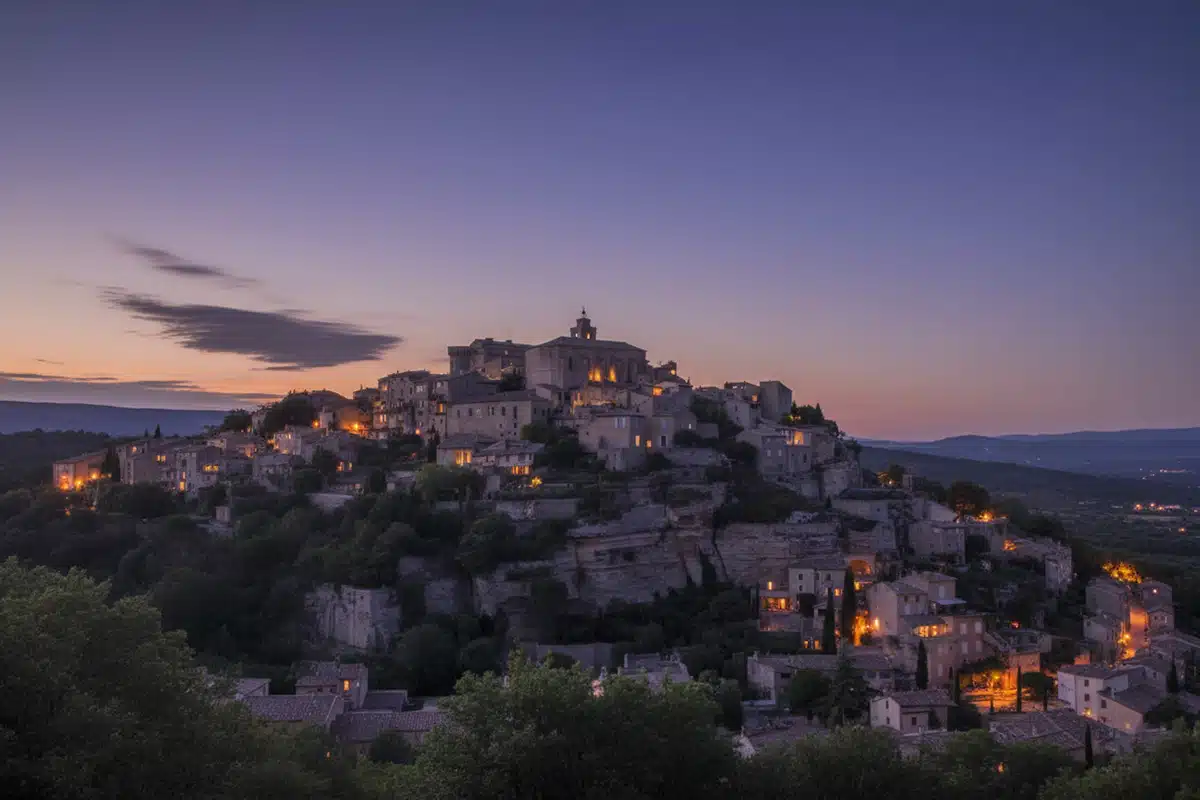 Vue nocturne paisible de la ville de Gordes, éclairée par les lumières des maisons, illustrant l’importance d’un système de sécurité dans un village calme.
